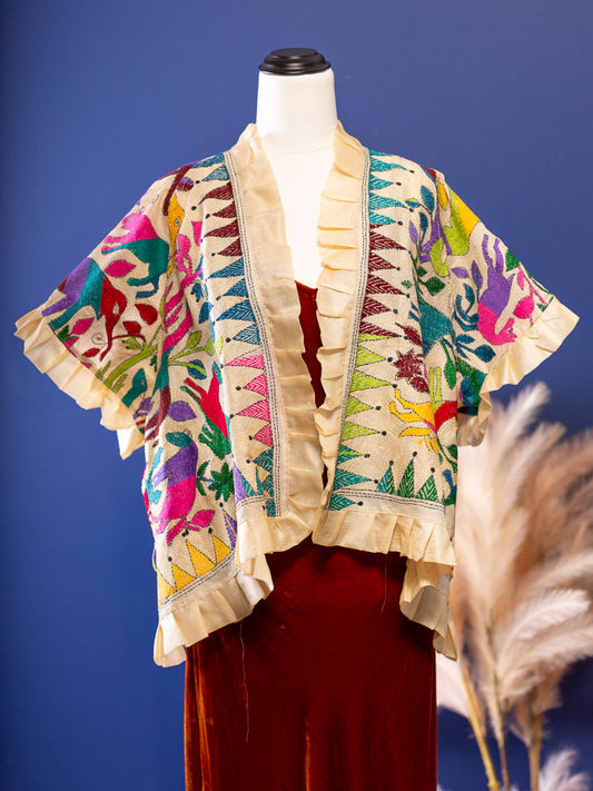 Hand embroidered silk jacket with animal theme in vivid colours on a cream backdrop
