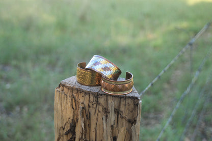 2 cuff bracelets on a stump of wood