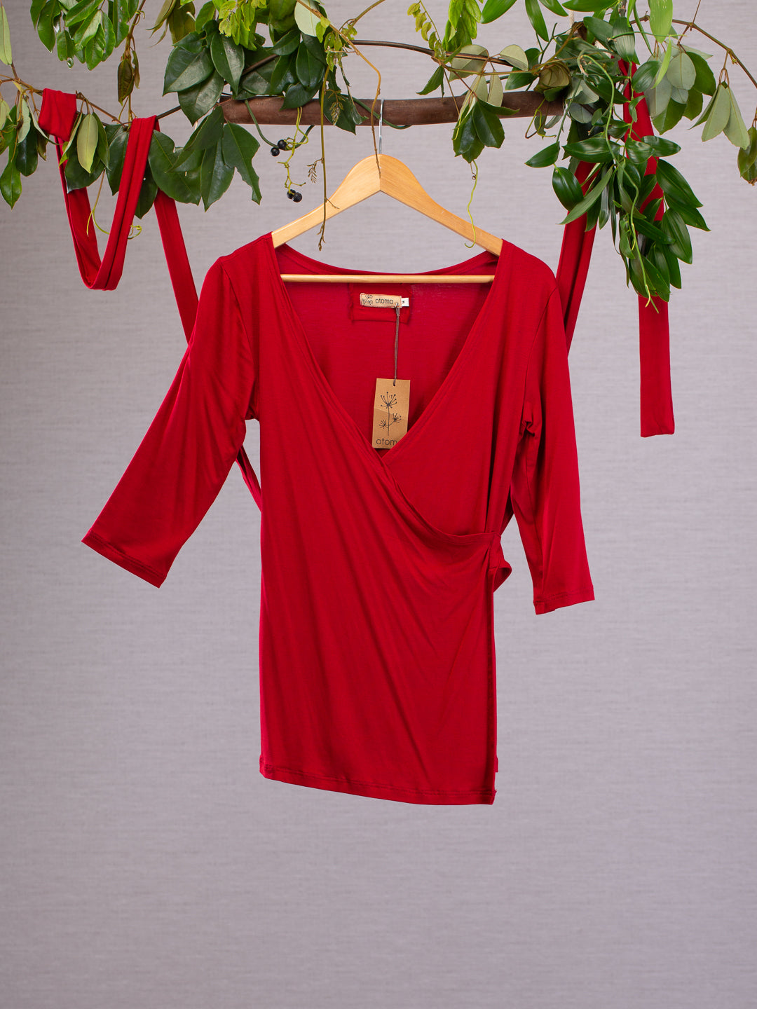 Red wrap-around top with long sashes on a hanger.